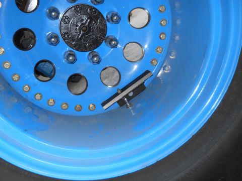 1992 Ford Bronco - Blue steel wheel with black center cap and tire, showing a mounted accessory.