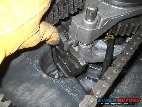 Engine timing chain and gears being adjusted by a gloved hand