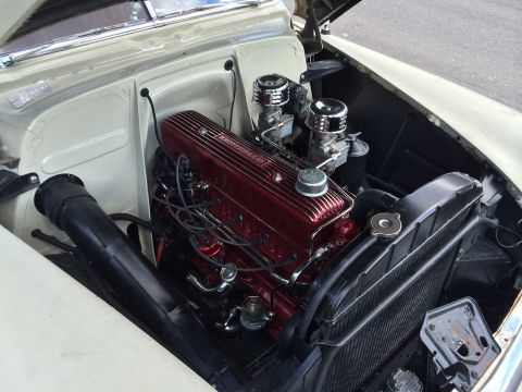 1964 Ford Fairlane - Close-up view of a vintage V8 engine with chrome accents and dual carburetors.