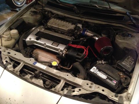 1990 Geo Storm GSi - The engine bay shows a DOHC 16V engine with an aftermarket air intake system and a red air filter.