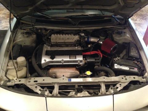 1990 Geo Storm GSi - Engine bay of a 1990 Geo Storm GSi, showing the DOHC 16V engine and aftermarket air intake.