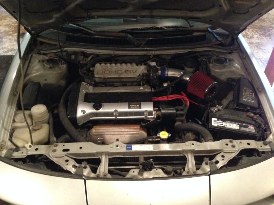 1990 Geo Storm GSi engine bay with DOHC 16V engine, red air filter, and battery