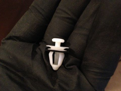 1990 Geo Storm GSi - A single white plastic fastener with a black washer is held in a gloved hand.