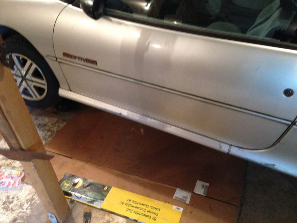 Silver car door with a red 'GSi' badge and a partial view of the front wheel