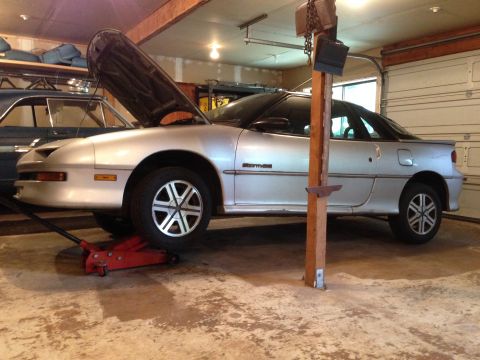 1990 Geo Storm GSi - Silver 1990 Geo Storm GSi undergoing maintenance in a garage.