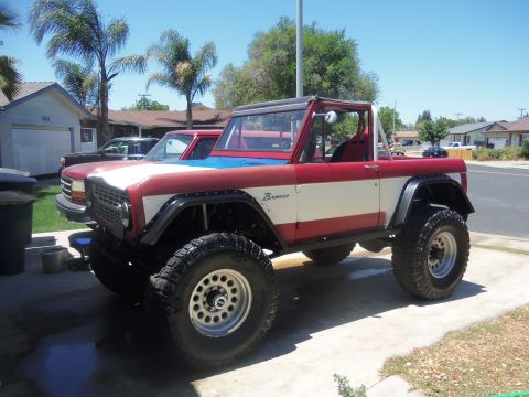 1968 Ford Bronco - A modified Ford Bronco sits in a driveway on a sunny day, with another vehicle partially visible behind it.