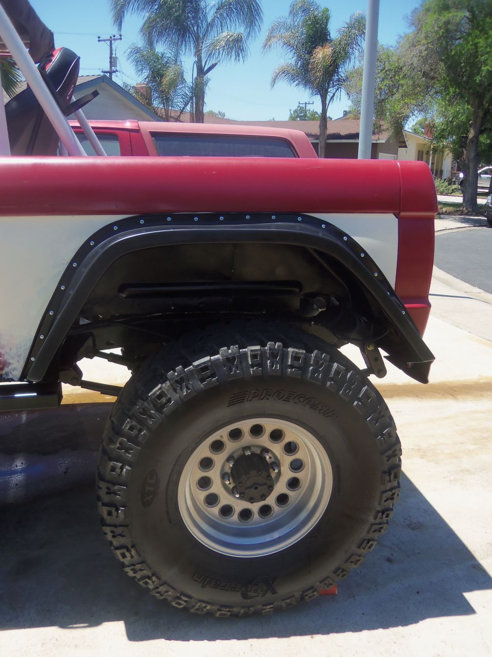 Rear fender and tire of a red and white SUV with aftermarket flares