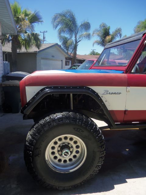 1968 Ford Bronco - Side view of a 1968 Ford Bronco showing its fender, large tire, and custom paint.