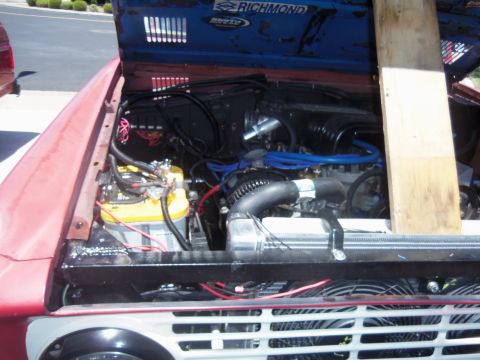 1968 Ford Bronco - The engine bay of a red vehicle is shown with various components and a "RICHMOND" sticker on the hood.