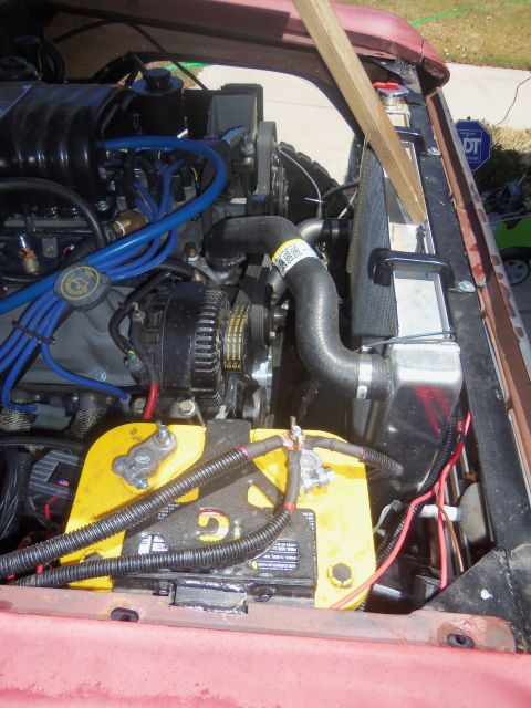 1968 Ford Bronco - Close-up view of the engine bay, highlighting the battery, radiator, and various engine components.