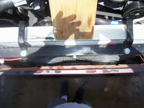 1968 Ford Bronco - Close-up view of a vehicle's radiator and fan assembly, with a wooden block obscuring part of the view.