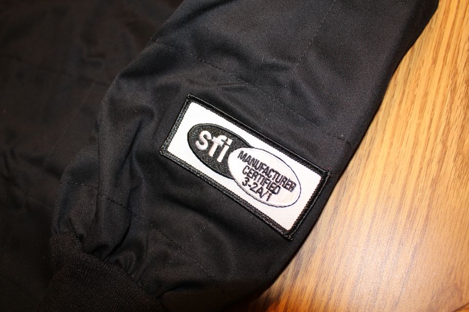 Close-up of SFI 3.2A/1 manufacturer certified patch on black racing jacket sleeve