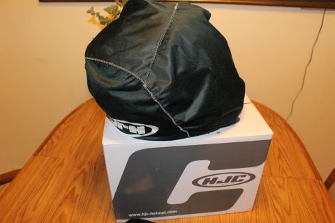 2003 Ford Crown Victoria - black drawstring helmet bag sits atop a white HJC-branded helmet box on a wooden table.