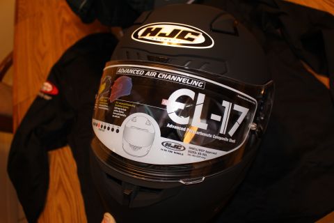 2003 Ford Crown Victoria - close-up of an HJC CL-17 helmet's visor showing the Advanced Air Channeling spec sticker and Snell/DOT approval text.