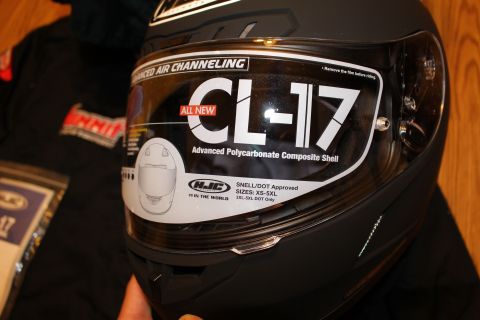 2003 Ford Crown Victoria - matte black HJC CL-17 full-face helmet held up, its clear shield bearing the All New CL-17 promotional decal.
