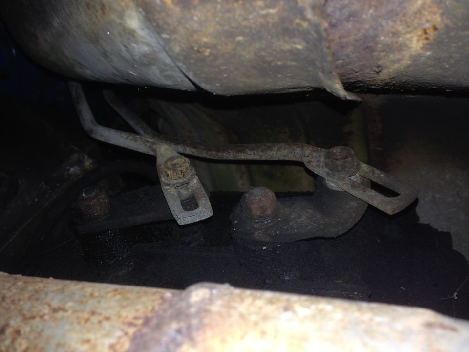 Close-up of rusty metal undercarriage components and fuel tank straps