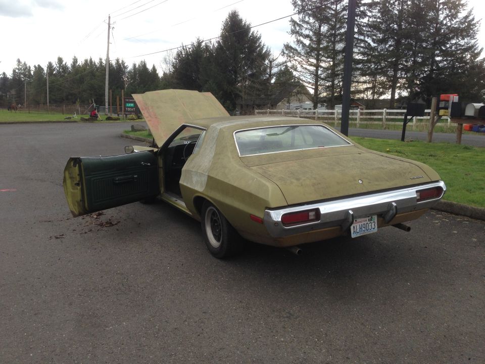 Gold 1973 Ford Torino sedan with hood and driver door open, parked on asphalt