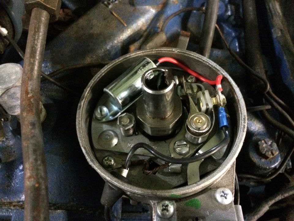 Close-up of a car's distributor cap interior with points and condenser visible