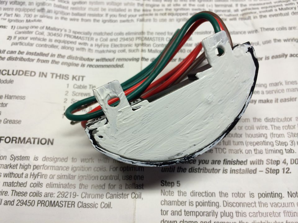 Mallory electronic ignition module with red, green, and black wires, resting on installation instructions