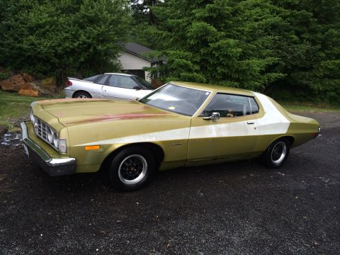 1973 Ford Torino - This 1973 Ford Torino coupe is parked outdoors next to another vehicle.