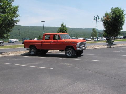 1979 Ford Bronco - This orange crew cab pickup truck has "BRONCO 40" written on its fender.