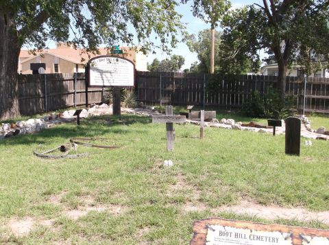 2009 Kenworth T800 - A historical cemetery scene features a large informational sign, wooden crosses, and weathered headstones.