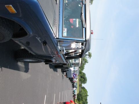 1979 Ford Bronco - A line of vehicles parked in a lot, with a blue Ford Bronco in the foreground.