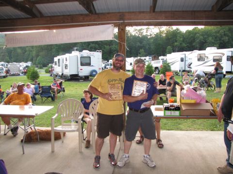 1979 Ford Bronco - Two men are holding awards at an outdoor event, with RVs parked in the background.