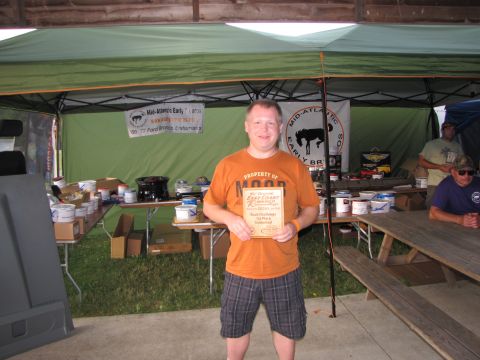 1979 Ford Bronco - A man proudly displays his award at an outdoor event with tents and picnic tables.