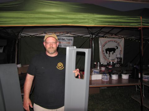 1979 Ford Bronco - Man holds a car door at an outdoor event with banners in the background.