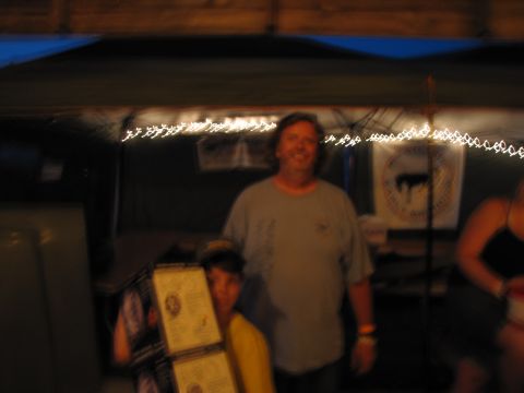 1979 Ford Bronco - People gather under a tent with decorative lights, one person holding up several documents.