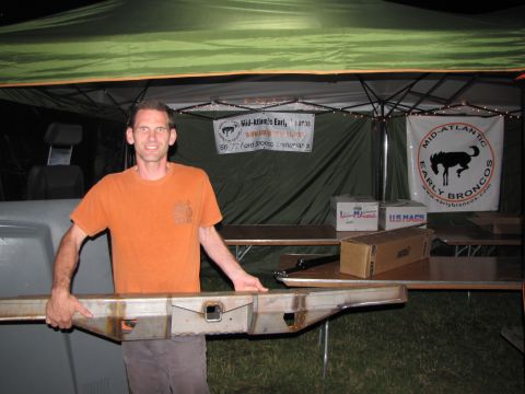 1979 Ford Bronco - Man displays a metal bumper at an event for early Ford Broncos.