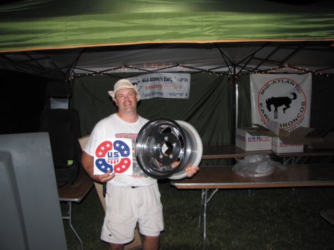 1979 Ford Bronco - Man displays wheels and US Made stickers at an event with a Mid-Atlantic Earl Broncos banner.