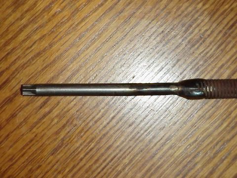 1989 Ford Bronco - A close-up view of a Torx screwdriver bit, showing its distinctive star-shaped tip against a wooden background.
