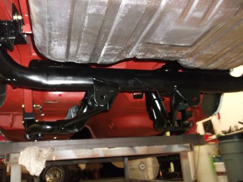 1967 Ford Mustang - Close-up of the rear suspension and fuel tank assembly on a vehicle's underbody.