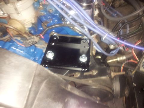 1976 Ford Ranchero - Close-up of a black bracket installed in an engine bay, showing bolted connections.