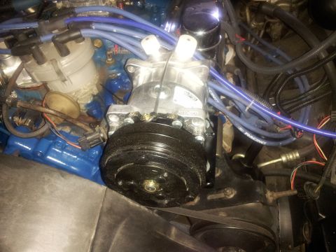 1976 Ford Ranchero - Close-up view of engine components, including an AC compressor and distributor cap.