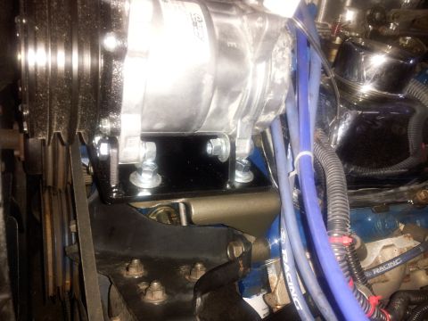 1976 Ford Ranchero - Close-up view of an air conditioning compressor and associated engine components, including blue spark plug wires.