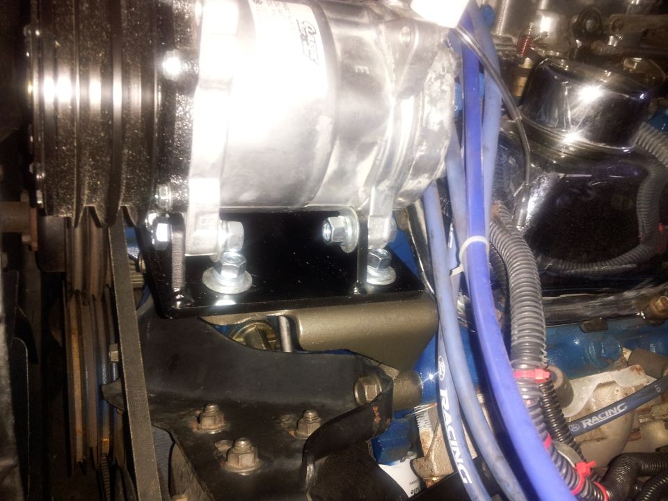 Air conditioning compressor mounted on engine with blue spark plug wires