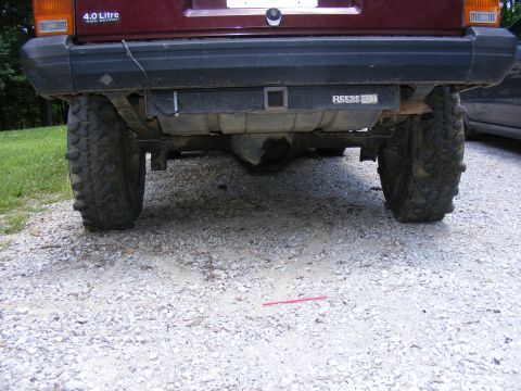 Maroon SUV rear axle with large tires and a Reese hitch receiver