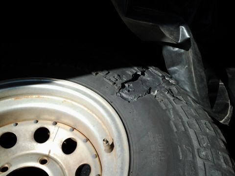 1978 Ford Bronco - A close-up shows a tire with significant damage, revealing its internal structure and a rusty wheel.