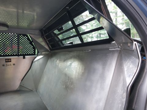 2001 Ford Crown Victoria - The interior of a police vehicle, likely modified for K-9 transport, features a metal partition and K-9 decals.