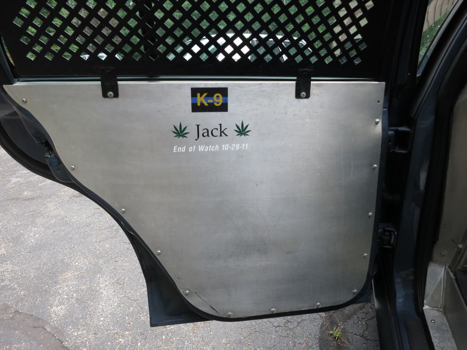 Police vehicle interior door panel with K-9 decal, name Jack, and 'End of Watch 10-29-11'