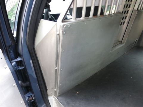 2001 Ford Crown Victoria - The interior of a police vehicle is shown, a metal partition and cage system.