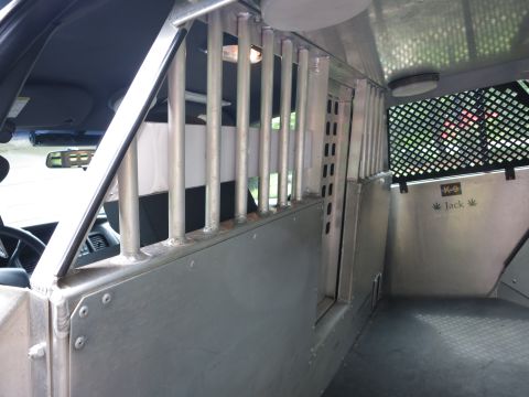 2001 Ford Crown Victoria - Modified interior of a police vehicle, likely for K-9 transport, with visible bars and labeling.