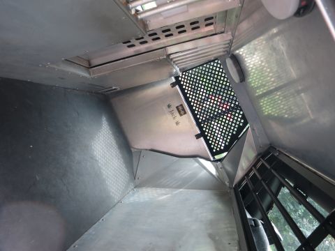 2001 Ford Crown Victoria - The interior of a vehicle compartment shows a metal construction with a grated partition and some visible text.