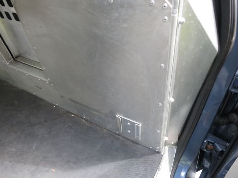 2001 Ford Crown Victoria - Interior view of a utility vehicle's cargo area, showing metal paneling and a rubberized floor.