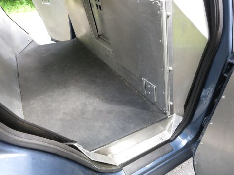 2001 Ford Crown Victoria - The interior of a vehicle's cargo area is shown, metal paneling and a rubber floor mat.
