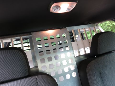 2001 Ford Crown Victoria - The interior of a vehicle is shown, a partition and cage system behind the front seats.