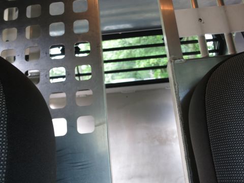 2001 Ford Crown Victoria - View from inside a vehicle, showing a metal partition and seats, with trees visible through the window.